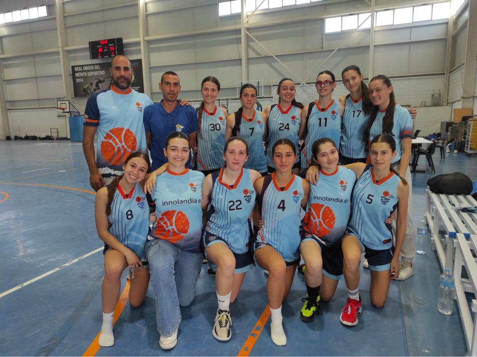 Equipo de baloncesto femenino posando con sus entrenadores